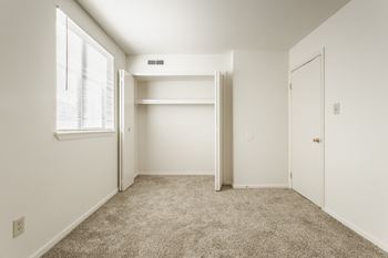 an empty bedroom with a closet and a window at Polo Run Apartments, Greenwood, 46142